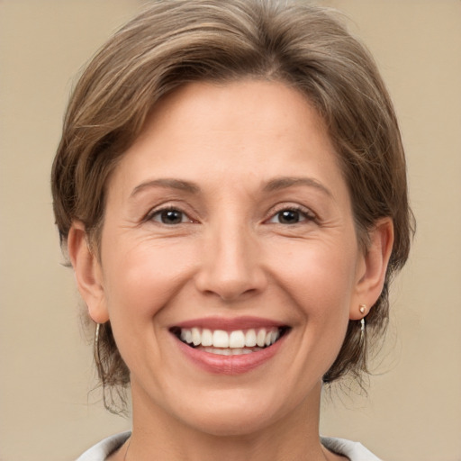 Joyful white adult female with medium  brown hair and grey eyes