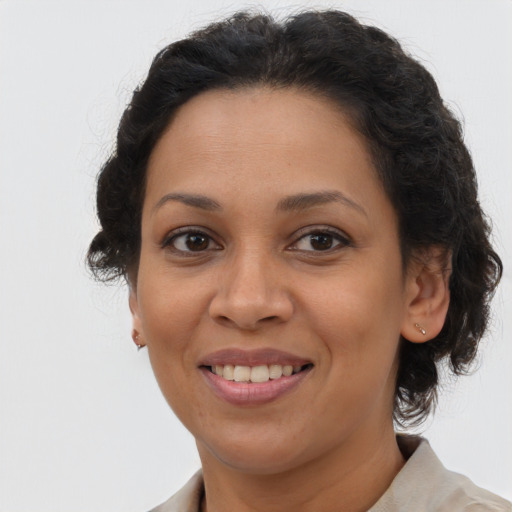 Joyful latino adult female with medium  brown hair and brown eyes