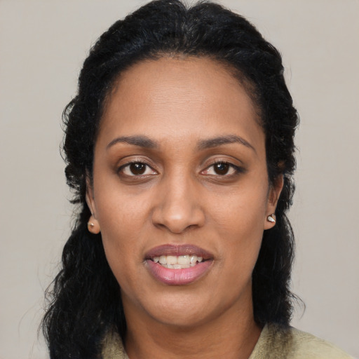 Joyful black young-adult female with long  black hair and brown eyes