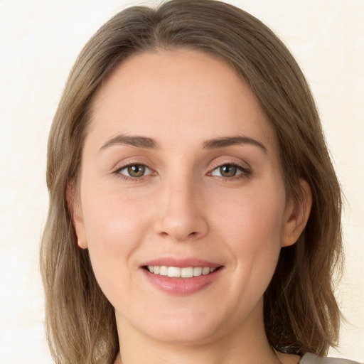 Joyful white young-adult female with medium  brown hair and green eyes