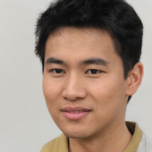 Joyful asian young-adult male with short  brown hair and brown eyes