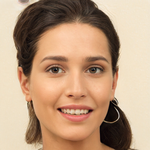 Joyful white young-adult female with long  brown hair and brown eyes