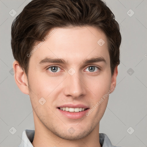 Joyful white young-adult male with short  brown hair and grey eyes