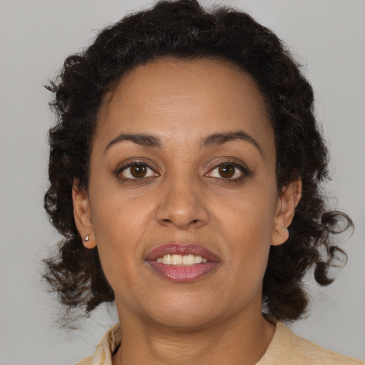 Joyful black adult female with medium  brown hair and brown eyes