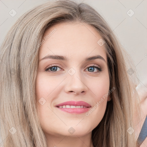 Joyful white young-adult female with long  brown hair and blue eyes