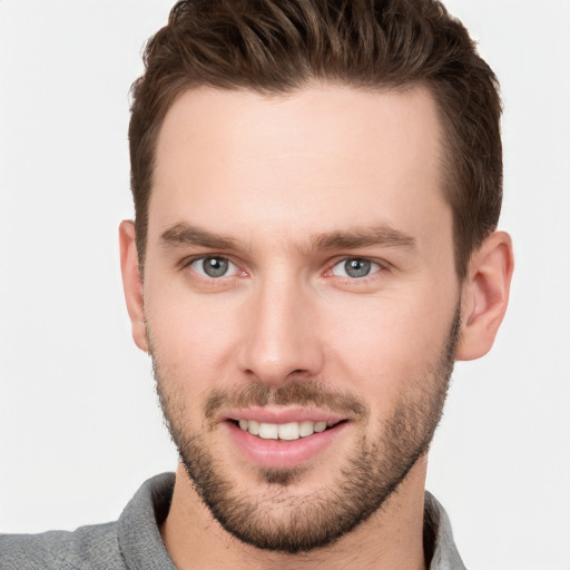 Joyful white young-adult male with short  brown hair and grey eyes