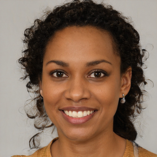 Joyful black young-adult female with medium  brown hair and brown eyes