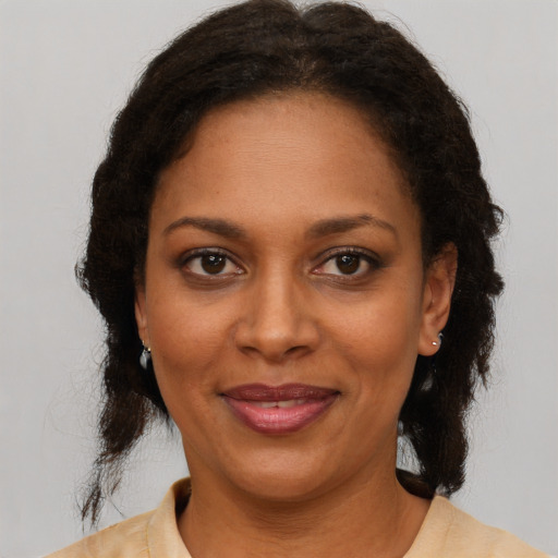 Joyful black adult female with medium  brown hair and brown eyes