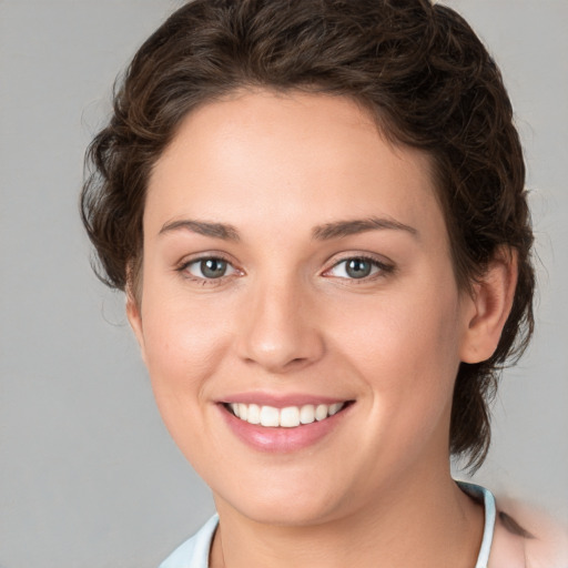 Joyful white young-adult female with medium  brown hair and blue eyes