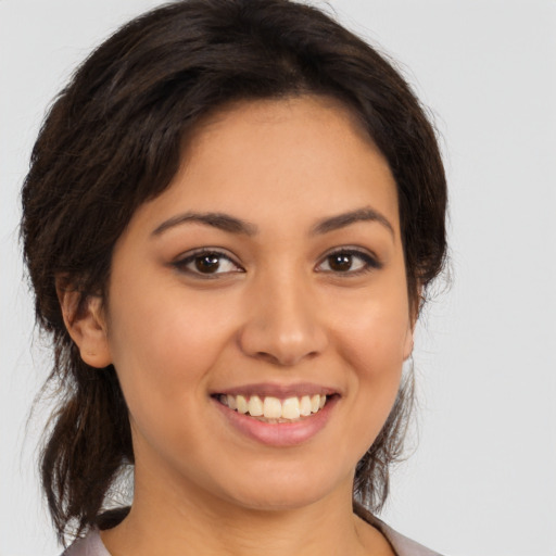Joyful latino young-adult female with medium  brown hair and brown eyes