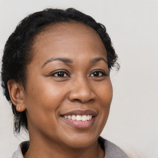 Joyful black young-adult female with short  brown hair and brown eyes