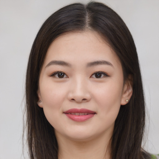 Joyful asian young-adult female with long  brown hair and brown eyes
