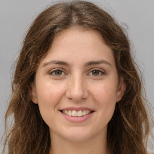 Joyful white young-adult female with long  brown hair and green eyes