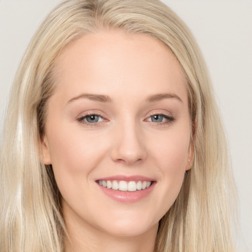 Joyful white young-adult female with long  brown hair and blue eyes