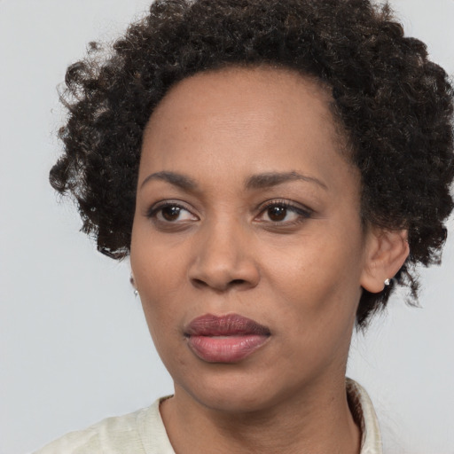 Joyful black adult female with short  brown hair and brown eyes