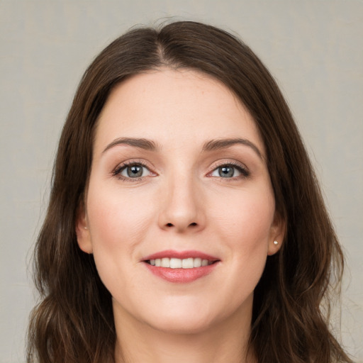 Joyful white young-adult female with long  brown hair and green eyes