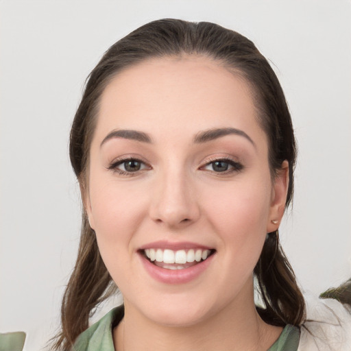 Joyful white young-adult female with medium  brown hair and grey eyes