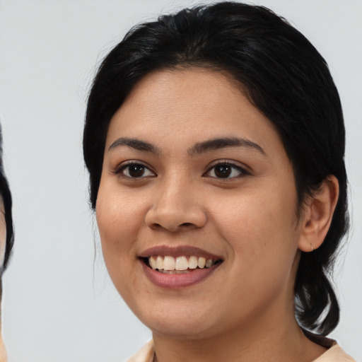 Joyful latino young-adult female with medium  black hair and brown eyes