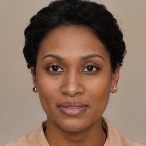 Joyful black young-adult female with short  brown hair and brown eyes