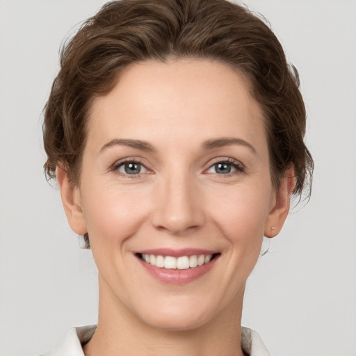 Joyful white young-adult female with short  brown hair and grey eyes