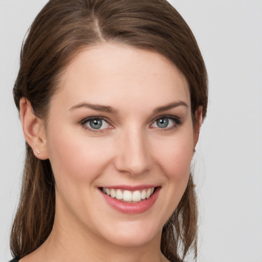 Joyful white young-adult female with medium  brown hair and grey eyes