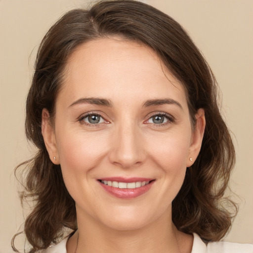 Joyful white young-adult female with medium  brown hair and grey eyes