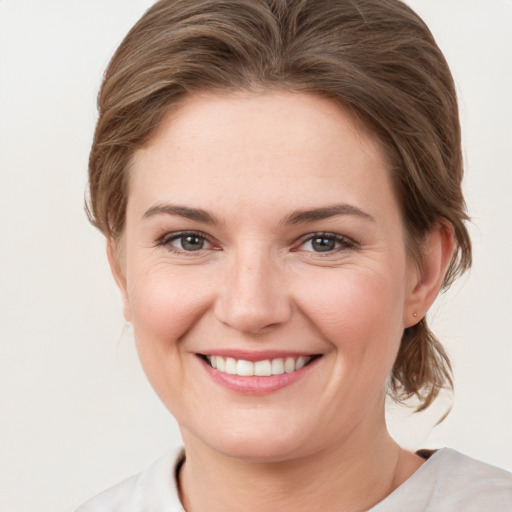 Joyful white young-adult female with medium  brown hair and grey eyes