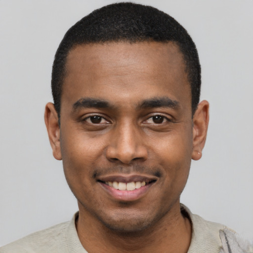 Joyful black young-adult male with short  black hair and brown eyes