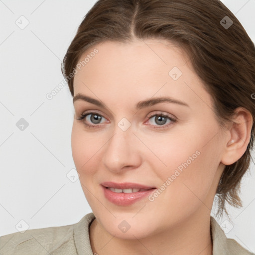 Joyful white young-adult female with medium  brown hair and grey eyes