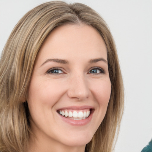 Joyful white young-adult female with medium  brown hair and green eyes