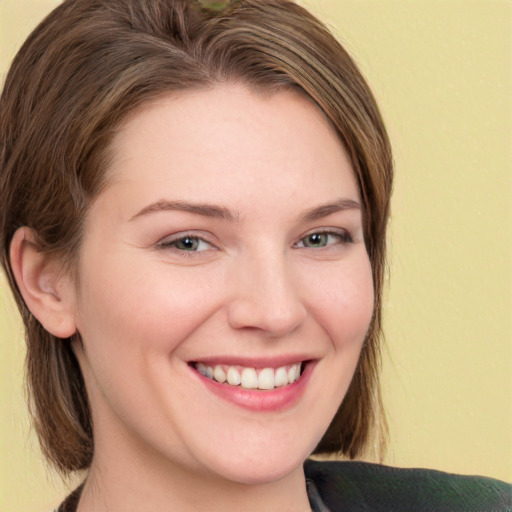 Joyful white young-adult female with medium  brown hair and green eyes