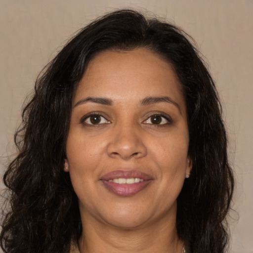 Joyful black young-adult female with long  brown hair and brown eyes