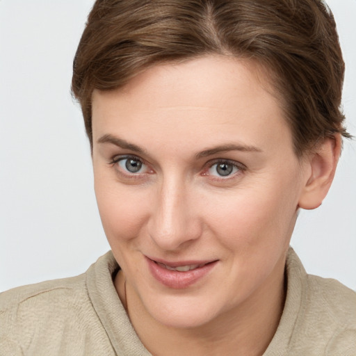 Joyful white young-adult female with short  brown hair and grey eyes