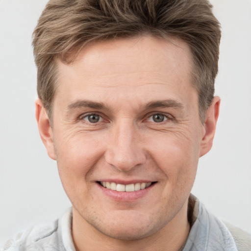 Joyful white adult male with short  brown hair and grey eyes