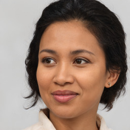 Joyful latino young-adult female with medium  brown hair and brown eyes