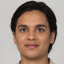 Joyful latino young-adult male with short  brown hair and brown eyes