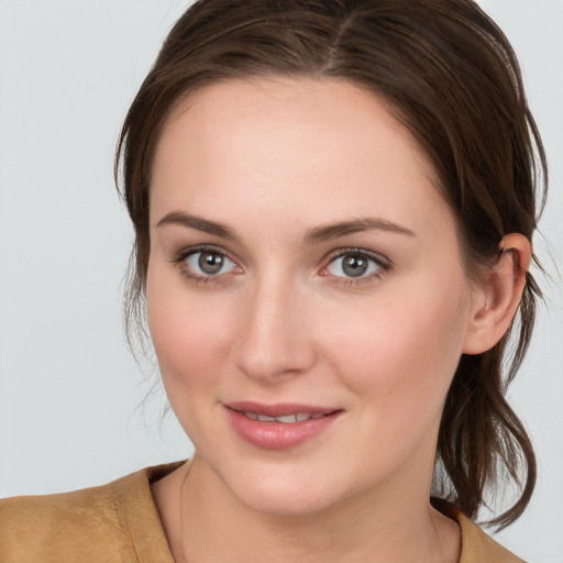 Joyful white young-adult female with medium  brown hair and grey eyes