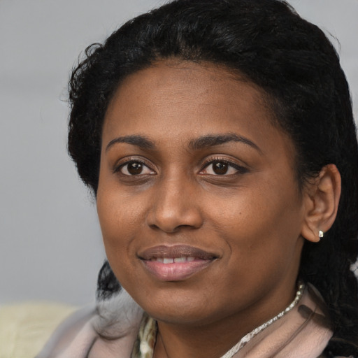 Joyful black young-adult female with short  black hair and brown eyes