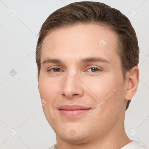 Joyful white young-adult male with short  brown hair and grey eyes