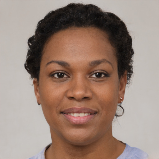 Joyful black young-adult female with short  brown hair and brown eyes
