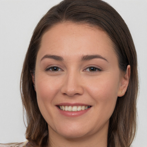 Joyful white young-adult female with long  brown hair and brown eyes