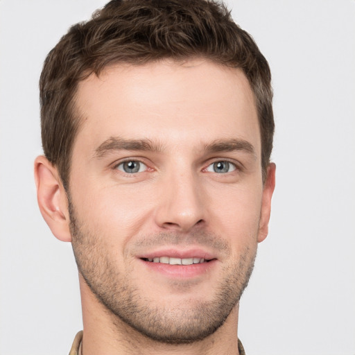 Joyful white young-adult male with short  brown hair and grey eyes