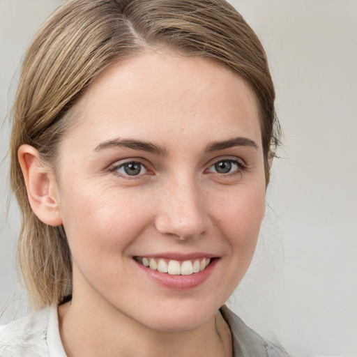 Joyful white young-adult female with medium  brown hair and blue eyes