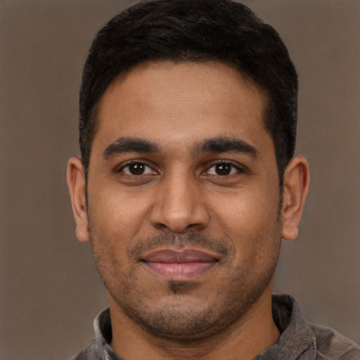 Joyful latino young-adult male with short  brown hair and brown eyes