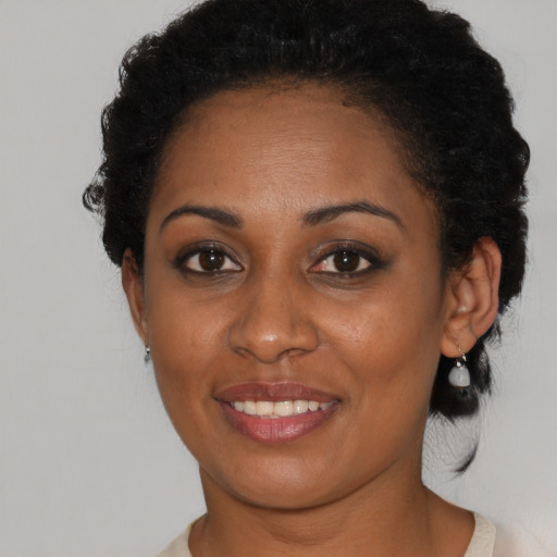 Joyful black young-adult female with short  brown hair and brown eyes