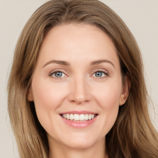 Joyful white young-adult female with long  brown hair and green eyes