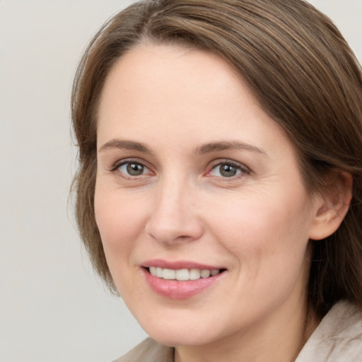 Joyful white young-adult female with medium  brown hair and grey eyes