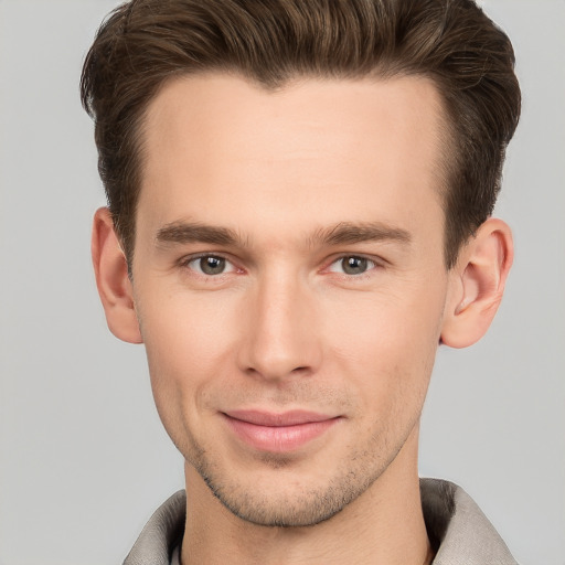 Joyful white young-adult male with short  brown hair and grey eyes