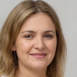 Joyful white adult female with long  brown hair and brown eyes