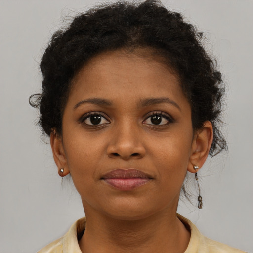 Joyful black young-adult female with short  brown hair and brown eyes